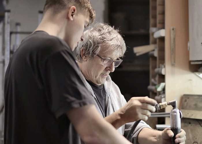 Two technicians collaborating in a workshop while working on EV charging station components for repair and maintenance.